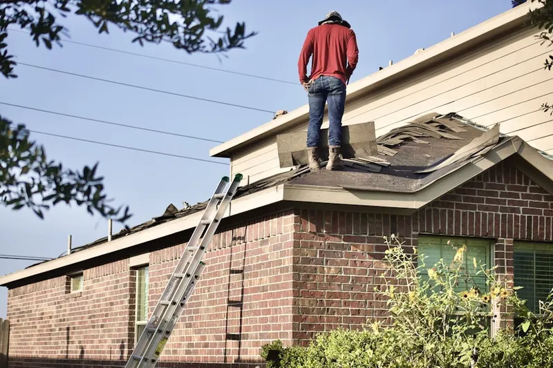 Professional roofer working on a residential roof in McIntosh Village